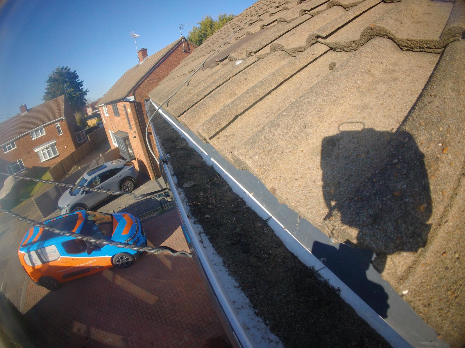 Clean gutter after professional clearing showing clear channel with no debris, Gutter Pro van below